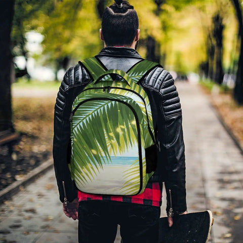 Sunlit Seaside Botanical Print Unisex Backpack on a person walking through a park