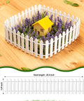 Three Piece 35 Inch White Mini Christmas Garden Fence For Fairy Gardens And Dollhouses Wood Picket Ornament Fence For Landscaping And Dollhouse Village DIY Build Easy To Install Durable Reusable Garden Decor shown as border around miniature house and flowers.
