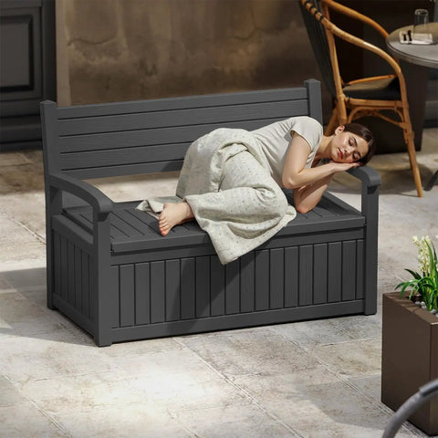 80 Gallon Outdoor Storage Bench With Wood Grain Style Resin Deck Box Waterproof And Lockable Storage Furniture in black with woman resting on it