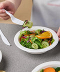 Person holding salad in 175 Pack 16 Oz Sugarcane Bagasse Soup Bowls Microwave Safe Heavy Duty Disposable For Hot Soups Desserts And Snacks Eco Friendly Compostable Dinnerware.