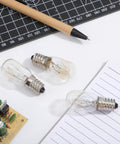 E14 Edison Fridge Bulbs Featuring Retro Tungsten Filament Emit A Legit Warm Yellow Glow Perfect For Microwave Ovens And Wine Coolers This Solid 15 Watt 3 Pack on a workspace with tools.