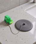 TEHAUX Silicone Bathtub Drain Stopper 15cm, Hair Catcher for Bathroom with playful green car design on countertop.