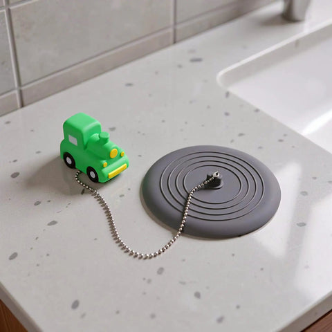 TEHAUX Silicone Bathtub Drain Stopper 15cm, Hair Catcher for Bathroom with playful green car design on countertop.