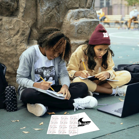 Two kids sitting outdoors using Light T Shirt Heat Transfer Paper Pack 10 Sheets 8.5x11 Printable HTV for DIY tee transfers.