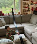 Child playing with Flexible Race Car Track Set with Pressure Suction Cups, Two Lane Slot Track, in living room during holiday season.