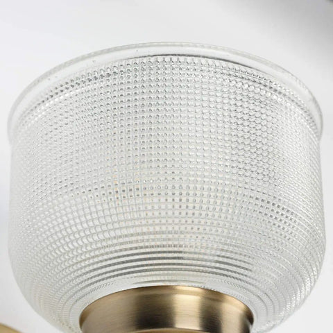 Close-up of Archie Collection Clear Double Prismatic Glass Coastal Bath Vanity Light Fixture with vintage brass finish