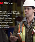 Worker wearing Pro Grade All Day Comfort Safety Glasses With Built In Magnifiers Plus 1.5 Reading Aid Dual Readers, gray-black frame