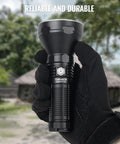 Person holding Catapult Pro SFT70 LED Flashlight Pocket Size Long Throw Beast Beam 1005m Range 2713 Lumens outdoors.