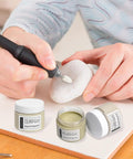 Person using Pro Grade 3000 Grit Diamond Polishing Paste on stone with jars of 15,000 and 60,000 grit paste nearby