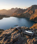Mavic 4 Pro Drone Fly More Combo Bundle for Creators on rocky terrain capturing lake and mountain view at sunset.