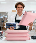 Man holding Bubble Mailers 10x13 Inch Light Pink 25 Pack Opaque Padded Envelopes for Clothing Books Makeup and Accessories at a counter