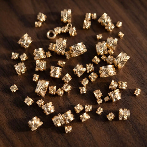 Assorted brass knurled threaded inserts displayed on a wooden surface from Brass Heat Set Inserts Kit