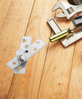 Close-up of Built To Last Stainless Pivot Door Hinges 2 Pack Concealed Offset Hinges with tools on wooden surface