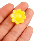 Hand holding a yellow flower-shaped luminous plastic clip, Colorful Flower Bike Spoke Beads Clip On Neon Glow In The Dark Decorations.