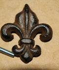 French Victorian Cabinet Knobs Pack Of 60 Cast Iron Fleur De Lis Hardware For 2-Inch Cabinets with screw on brown surface