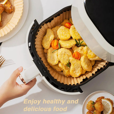 Go-To 6.5 Inch Round Air Fryer Paper Liners, 100 Pack Nonstick Parchment Paper in air fryer with cooked nuggets