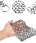 Hand holding 8x6 Inch Cast Iron Chainmail Scrubber for Safe Scratch Free Cleaning of Pre Seasoned Pans Griddles Barbecue Grills and Pots.