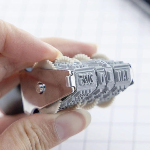 Close-up of Sleek Rotating Date Stamp With Premium Dedicated Black Ink Pad And 12 Year Dial Bands in use.