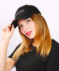 Woman wearing a customizable adjustable baseball cap for men and women with your text logo or image, breathable 100 percent cotton six panel trucker sun hat with pre curved bill and metal buckle closure, ideal gift for travel and everyday outings.