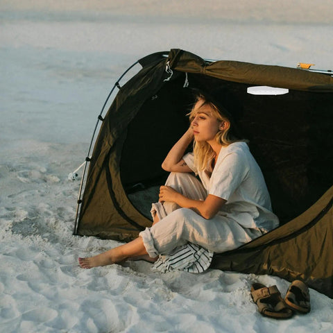 Woman sitting by tent at beach with Portable Round Camping Lantern With LED Lights For Outdoor Use Waterproof Tent Light