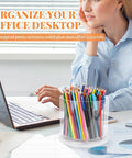 Person working at desk with clear acrylic organizer holding colored pencils and pens