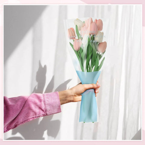 Hand holding tulip bouquet wrapped in 150 Pack Flower Bouquet Sleeves With Plastic OPP Wrapping Bags, DIY Friendly Protective Floral Packaging.