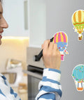 Woman in kitchen using Colorful Hot Air Balloon Sticky Notes Pack Of 12 Styles With 50 Sheets Each Mini Notebooks for reminders.