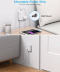 Legit Flat Plug Extension Cord With Four Wide Spaced Outlets And Dual Usb Type C Fast Charging Power Strip mounted to wall near a sofa.