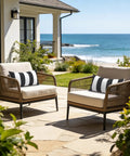 Outdoor Indoor Lumbar Pillows Pack Of 2 Cushions For Patio And Home Sofa Use Water Repellent Fluffy All Weather Cushions 12x20 Inch Cabana Black displayed on patio chairs by the sea.