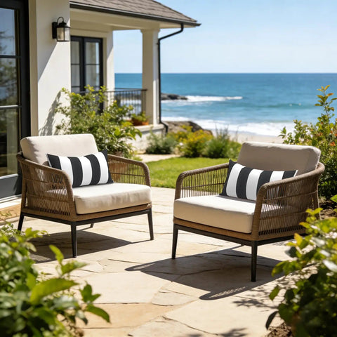Outdoor Indoor Lumbar Pillows Pack Of 2 Cushions For Patio And Home Sofa Use Water Repellent Fluffy All Weather Cushions 12x20 Inch Cabana Black displayed on patio chairs by the sea.