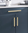 Golden Champagne Cabinet Pull Concentric Modern Style Five And One Sixteenth Inch Center To Center installed on blue kitchen cabinets.