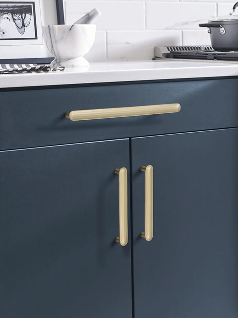 Golden Champagne Cabinet Pull Concentric Modern Style Five And One Sixteenth Inch Center To Center installed on blue kitchen cabinets.