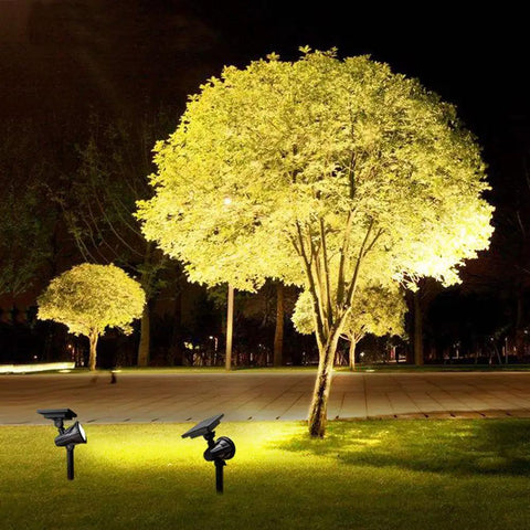 Solar Spotlight With Remote Control, 9 Color Auto Change Or Fixed Modes For Yard, Bright Tree Lighting, Bigger Solar Panel For Strong Winter Performance illuminating a tree at night.