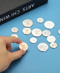 Hand holding a Two Pack Copper Discs One Inch Cu High Density Pure Copper Discs 0.9995 Purity among other metal discs.