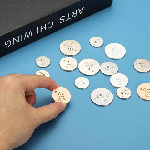 Hand holding a Two Pack Copper Discs One Inch Cu High Density Pure Copper Discs 0.9995 Purity among other metal discs.