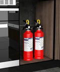 No Fuss ABC Home Fire Extinguisher 2.5 Lb Two Pack in kitchen cabinet, red steel tanks ready for use.