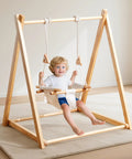 Child seated in Canvas Indoor Outdoor Baby Swing For Infants To Toddler With 3 Point Safety Belt Soft Cushioned Seat And Beech Wood Dowels Durable Hammock Chair For Nursery Patio Or Tree.