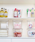 Hella Nifty Clear Stackable Storage Bins With Secure Snap Lids And Comfortable Side Handles And Large 6 Pack Real Deal Option For Kitchen Pantry Closet Fridge Under Sink Bathroom Organization filled with toiletries and beauty products.
