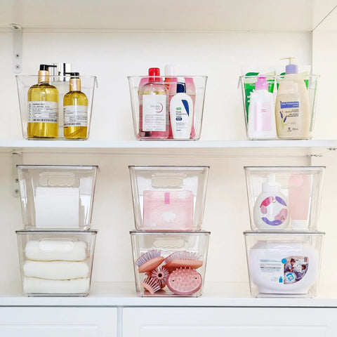Hella Nifty Clear Stackable Storage Bins With Secure Snap Lids And Comfortable Side Handles And Large 6 Pack Real Deal Option For Kitchen Pantry Closet Fridge Under Sink Bathroom Organization filled with toiletries and beauty products.