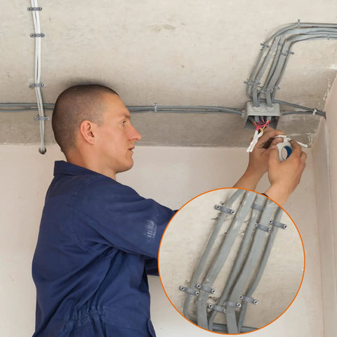 Electrician using heavy duty PVC conduit clamps 2 hole U clip straps for half inch cables and pipes on ceiling installation.