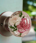 Vintage floral resin cabinet handles with pink and white carnation design, 48mm round, on sturdy metal backing for furniture upgrades.