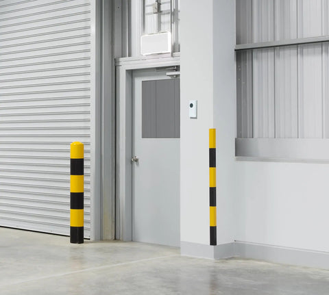 Industrial interior space showing a closed metal garage door and security bollards, suited for various business environments.