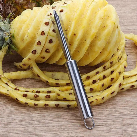 Pineapple Eye Remover And Core Cutter Tool V Shaped Stainless Steel Kitchen Gadget For No Fuss Quick Fruit Prep next to peeled pineapple.
