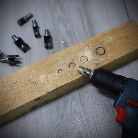 Drill with 8 Piece Wood Plug Cutter Drill Bit Set With Pro Grade Titanium Coated Carbon Steel Bits on wooden board