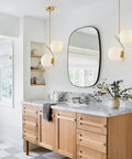 Two Light Glass Globe Pendant Light In Brushed Brass Gold Finish Modern Mid Century Style For Kitchen Island Large White Glass Globes Round Hanging Ceiling Light Sleek Contemporary Fixture over a kitchen countertop.