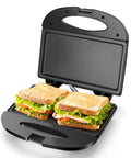 Aigostar Flat Sandwich Maker With Nonstick Deep Grill Surface, Black. Sandwiches with lettuce and turkey in an open grill.
