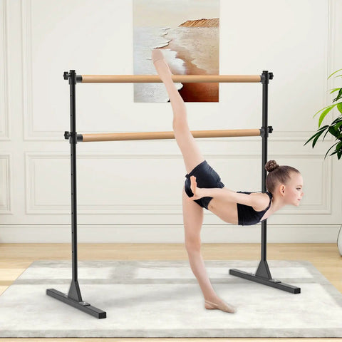 Child using 4 Foot Height Adjustable Freestanding Wooden Ballet Barre With Double Bar Heavy Duty For Your Home Gym Dance Barre Portable 350 Lb Capacity For Stretching Practice And Everyday Fitness in home studio.