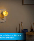 SleepLite Jewel Amber Led Night Light Plug In Always On Energy Efficient UL Certified 2 Pack illuminating a bathroom wall