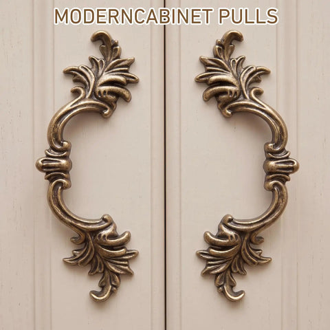 10 Pack Vintage Cabinet Pulls in Antique Brass Finish With 2.5 Inch Center Hole, ornate design on cream cabinet doors.