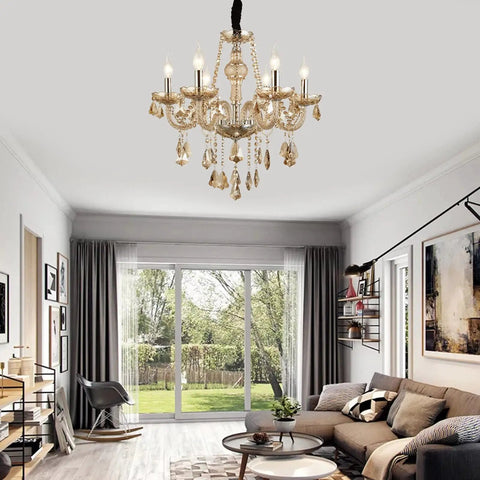 6 Light Crystal Chandelier With Metal Frame And Six Arms Vintage Candle Style Pendant Ceiling Light Cognac Finish With Raindrop Crystals Dimmable Bulbs Compatible 23 Inch Diameter 22 Inch Height Adjustable Chain Up To 47 Inches in a living room setting.